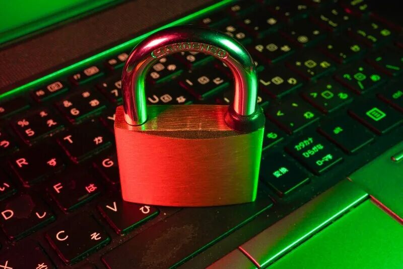 Password manager dashboard on a laptop showing a secure credential vault and team sharing for a small business