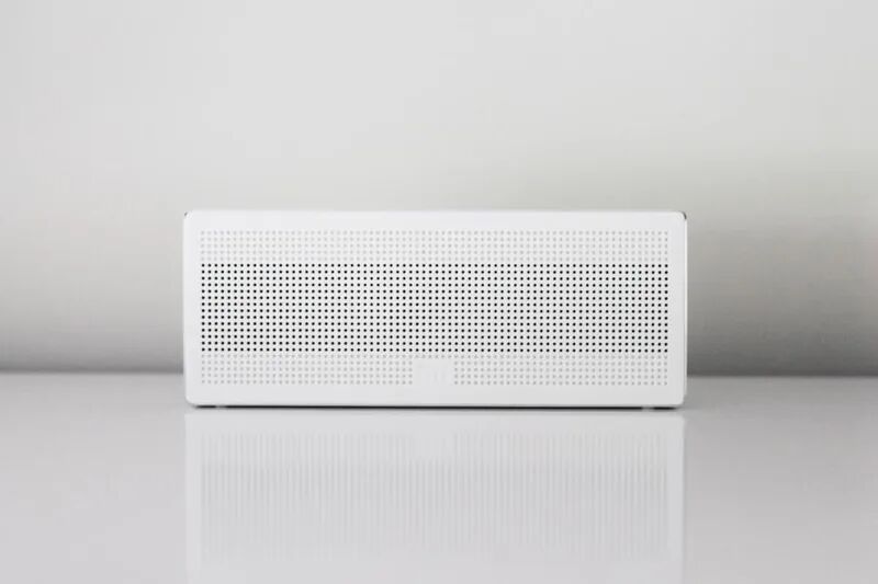White smart speaker on a table, representing smart home and IoT device security